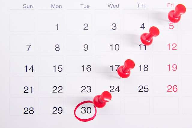 A calendar with red pins in it, symbolic of monthly eCommerce bookkeeping.