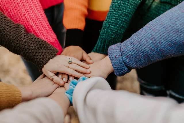 People place their hands together as a team, symbolic of us teaming up with SD businesses.